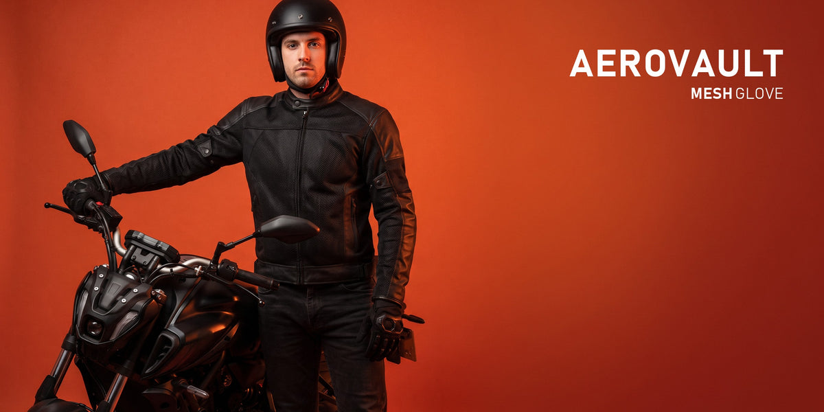 AeroVault mesh glove — rider beside a motorcycle on a burnt orange studio backdrop