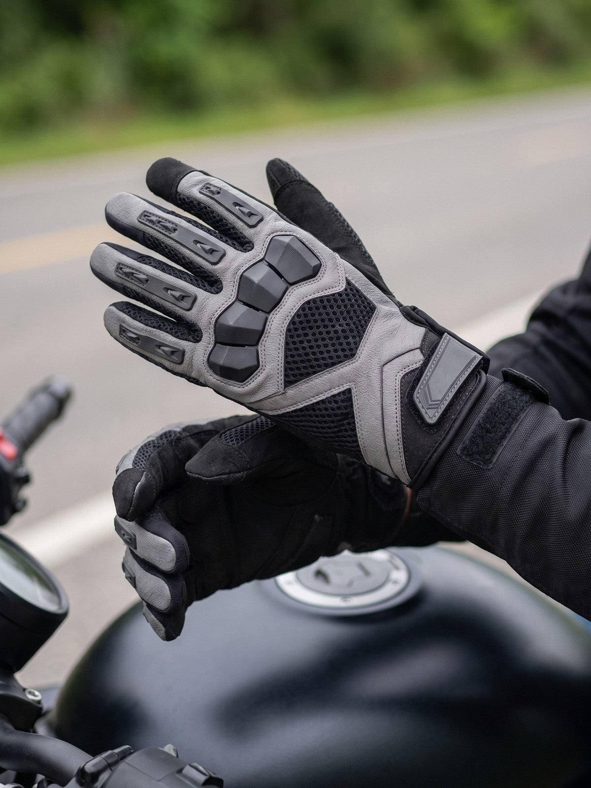Rider tightening the cuff of a black touchscreen mesh glove